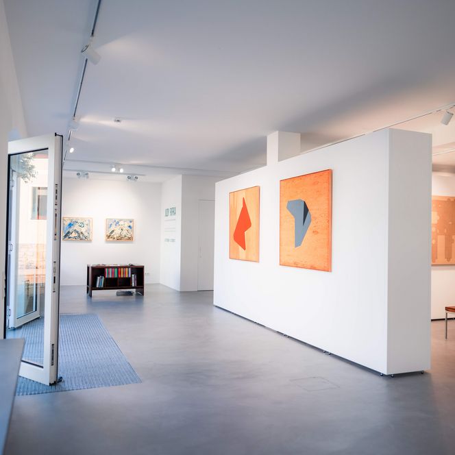 Innenansicht einer Galerie mit mehreren Gemälden.