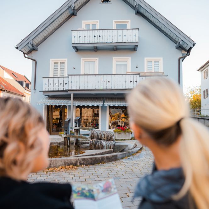Zwei Personen betrachten ein Haus auf dem Kunstspaziergang.