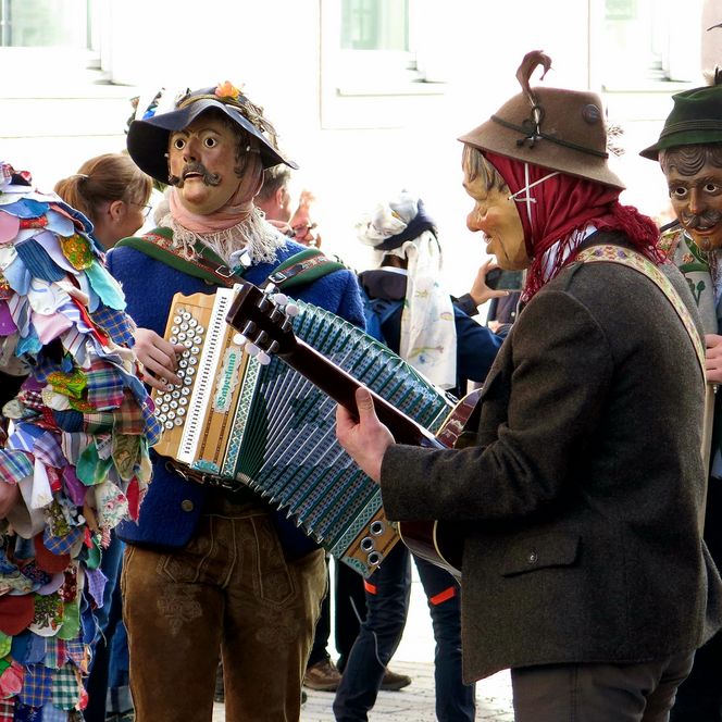 Maschkera in traditionellen Kostümen beim Umzug durch den Murnauer Markt. 