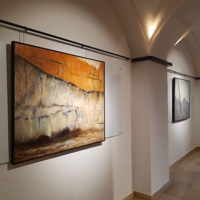 Zwei Gemälde hängen in der Ausstellung im Rathaus Foyer.