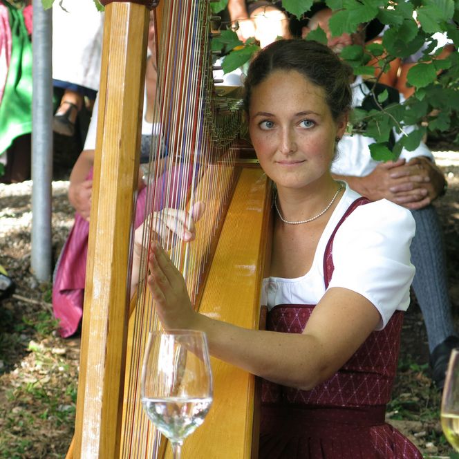 Musikantin spielt Harfe.
