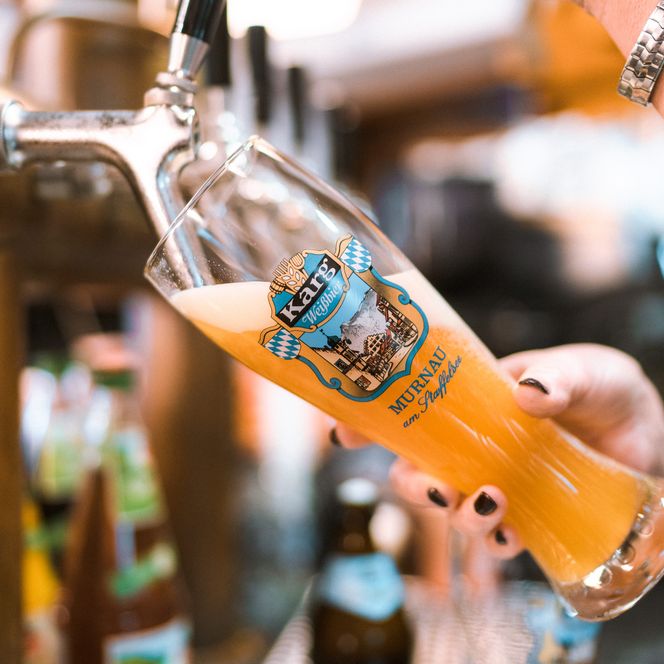 Weißbier wird in ein Glas eingeschenkt