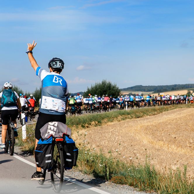 Teilnehmer der BR-Radltour fahren auf einer Landstraße.