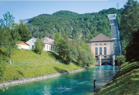 Außenansicht des Walchenseekraftwerks mit Fluss.