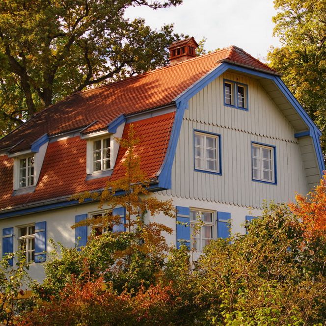Das Münter Haus von außen, umgeben von Bäumen mit Herbstlaub.