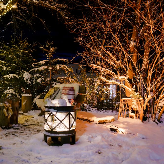 Laterne im Schnee mit Lichterketten im Schlossgarten Murnau